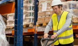 Warehouse operative using an industrial floor scale to weigh a pallet
