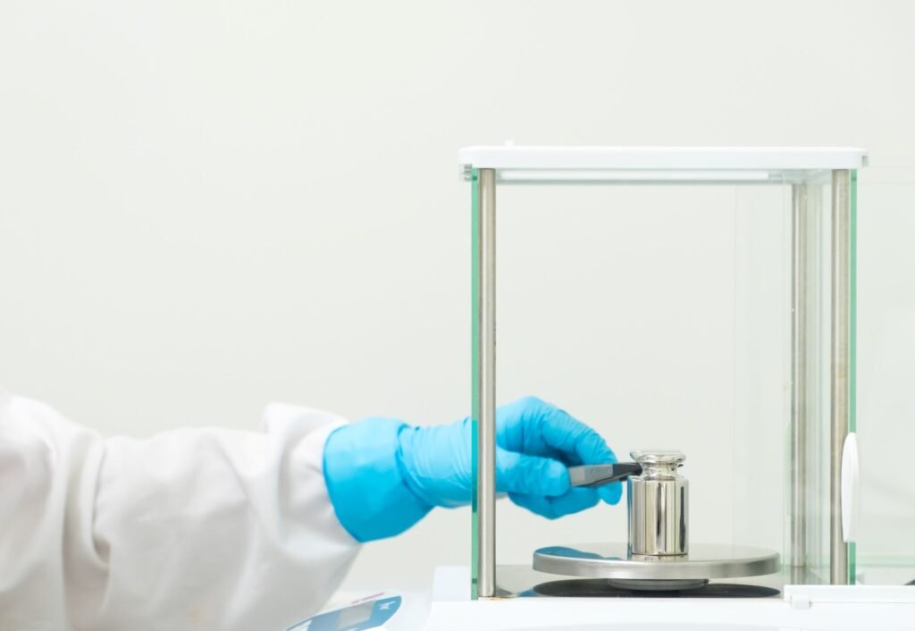 Analytical balance with internal automatic calibration performing a calibration routine in a pharmaceutical quality control laboratory
