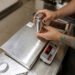 Calibration technician using NIST-traceable certified test weights to calibrate a heavy-duty industrial floor scale in a manufacturing facility