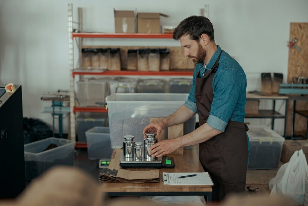 Warehouse operator placing certified test weights on a shipping scale for daily in-house verification check between professional calibration events