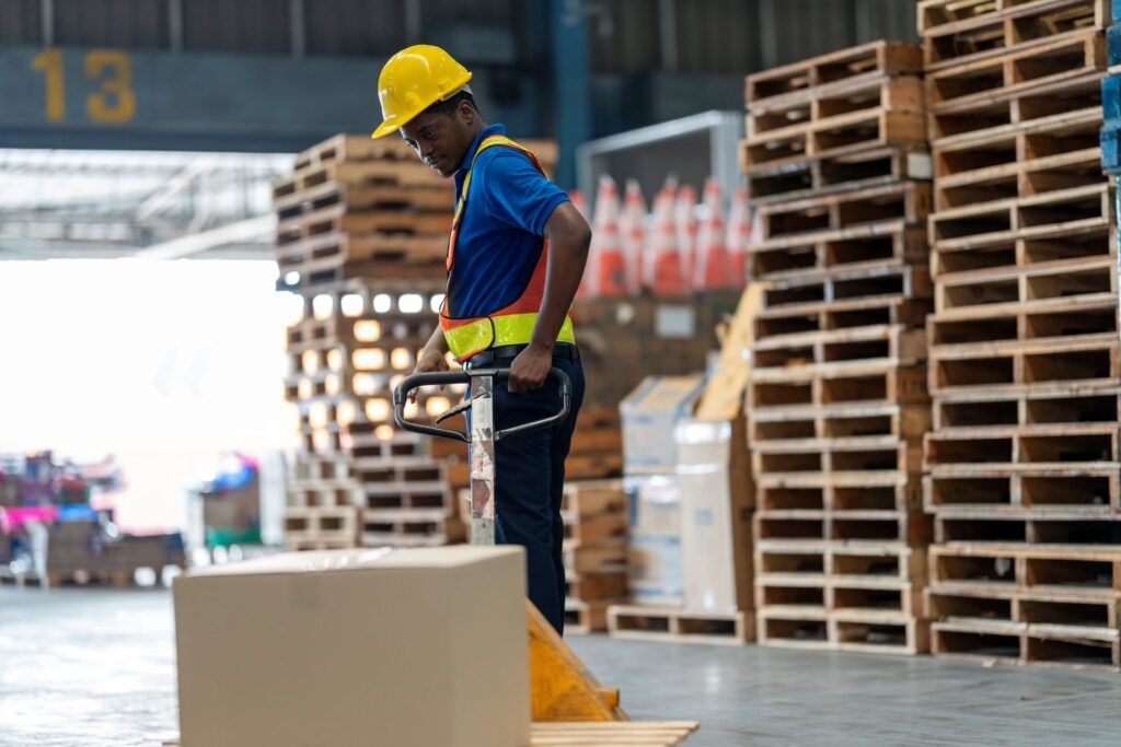 Warehouse operator using a pallet jack scale at a shipping dock to weigh a pallet before LTL carrier pickup