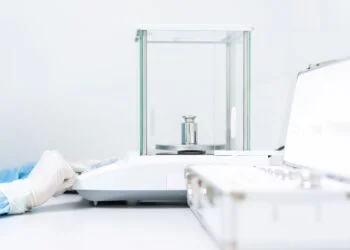 Laboratory analyst performing a ten-replicate precision verification test on an analytical balance using a certified reference weight