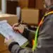 Warehouse shipping manager reviewing a completed Bill of Lading document at a loading dock before LTL carrier pickup