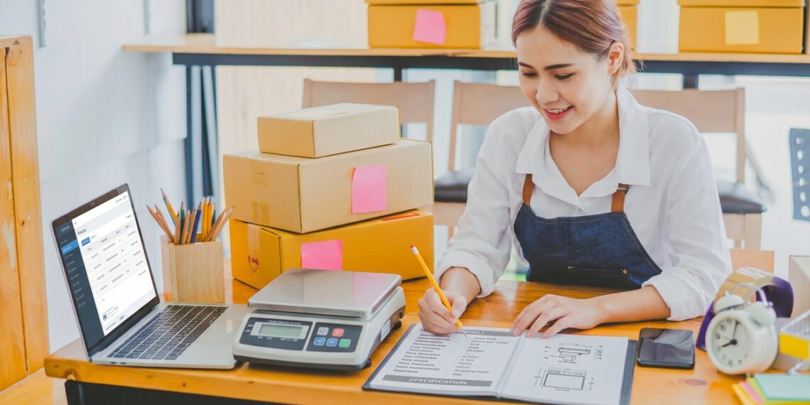 Business owner at a packing station using a USB-connected shipping scale to weigh packages before generating shipping labels