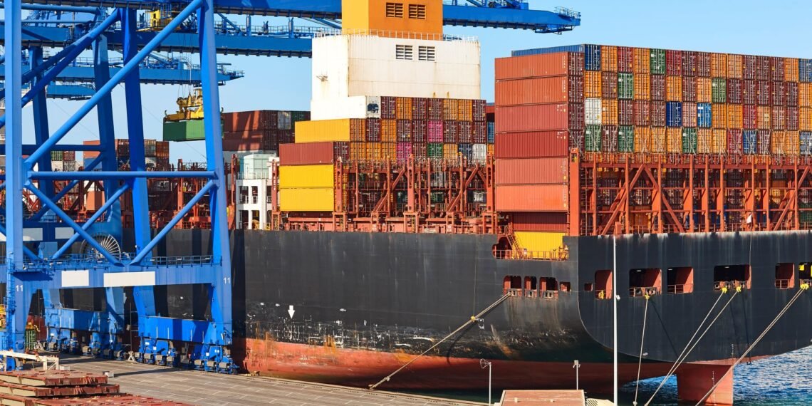 Loaded shipping containers being lifted by crane at a port terminal before vessel loading under SOLAS VGM requirements