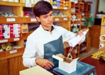 Warehouse operator using a counting scale to verify the quantity of small metal fasteners in a parts bin during inventory management