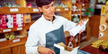 Warehouse operator using a counting scale to verify the quantity of small metal fasteners in a parts bin during inventory management
