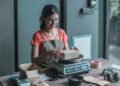 Small business owner weighing a package on a bench top parcel scale at an ecommerce packing station