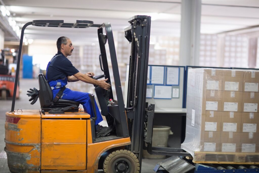 Industrial floor scale at a warehouse receiving dock with a loaded pallet being weighed using a pallet jack