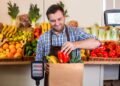 Grocery store produce department with digital price computing scale showing weight and price per pound for fresh fruits and vegetables