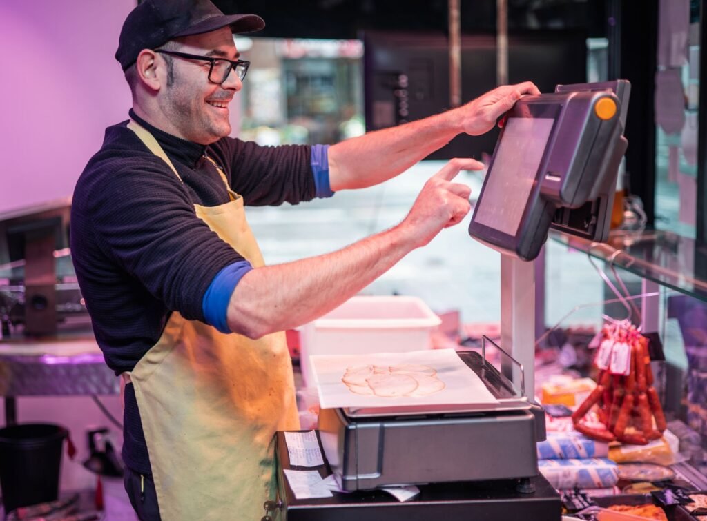 Deli scale with integrated thermal label printer producing a price-embedded barcode label for pre-packaged food products in a grocery store deli department