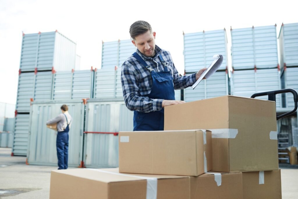 Warehouse operator recording outbound pallet weight on a floor scale before staging freight for LTL carrier pickup and bill of lading preparation