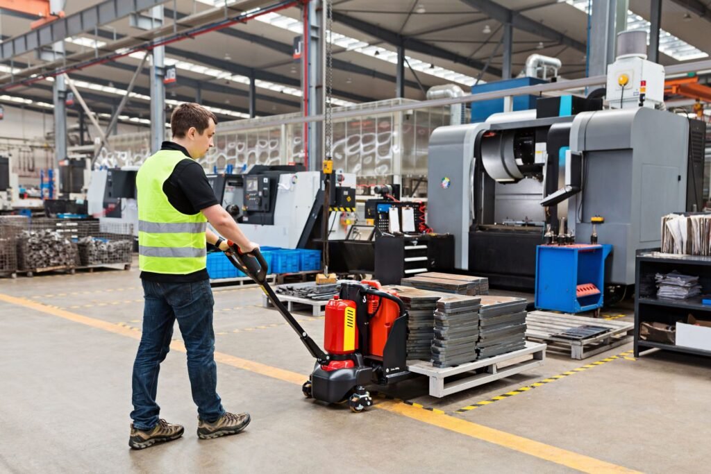 Worker using a pallet jack to load goods onto an industrial floor scale via steel access ramps in a warehouse