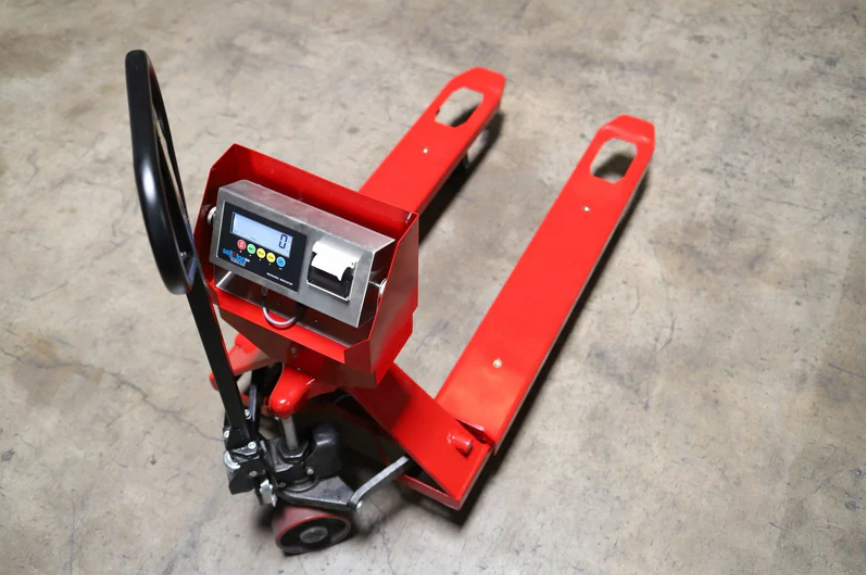 Close-up of a pallet jack scale digital indicator display with integrated weight ticket printer showing gross, tare, and net weight