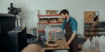 Digital parcel scale at an e-commerce packing station with packages ready for carrier pickup and shipping label printing