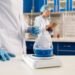 Pharmaceutical QC analyst weighing an active pharmaceutical ingredient on an analytical balance in a GMP compliant laboratory