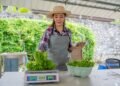 Vendor at a farmers market using an NTEP-certified portable price computing scale with dual display to weigh fresh produce for a customer