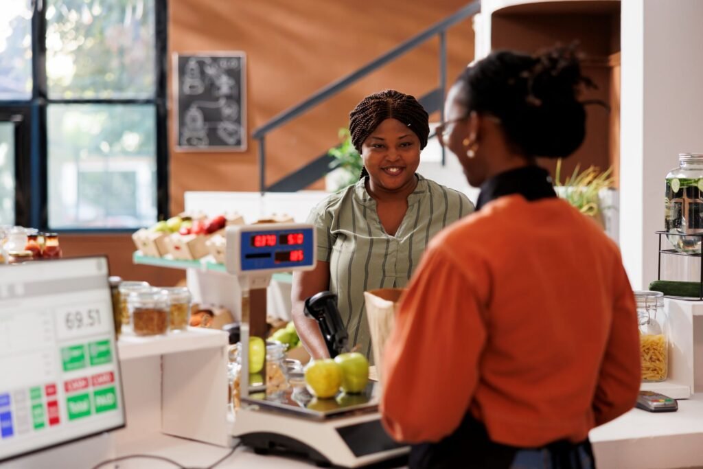 Price computing scale with dual display showing weight and total price on both the operator-facing and customer-facing screens at a grocery produce counter