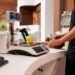 Business owner reviewing retail scale options at a deli counter showing price computing scale with dual customer display