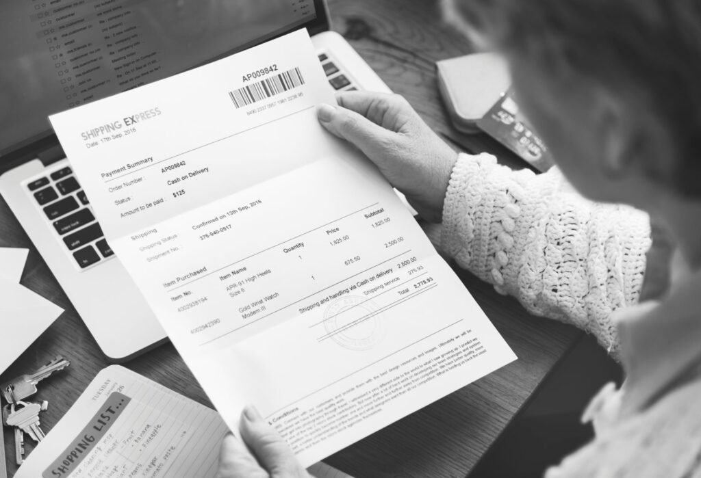Logistics manager reviewing carrier shipping invoice adjustments and surcharge line items on a computer screen