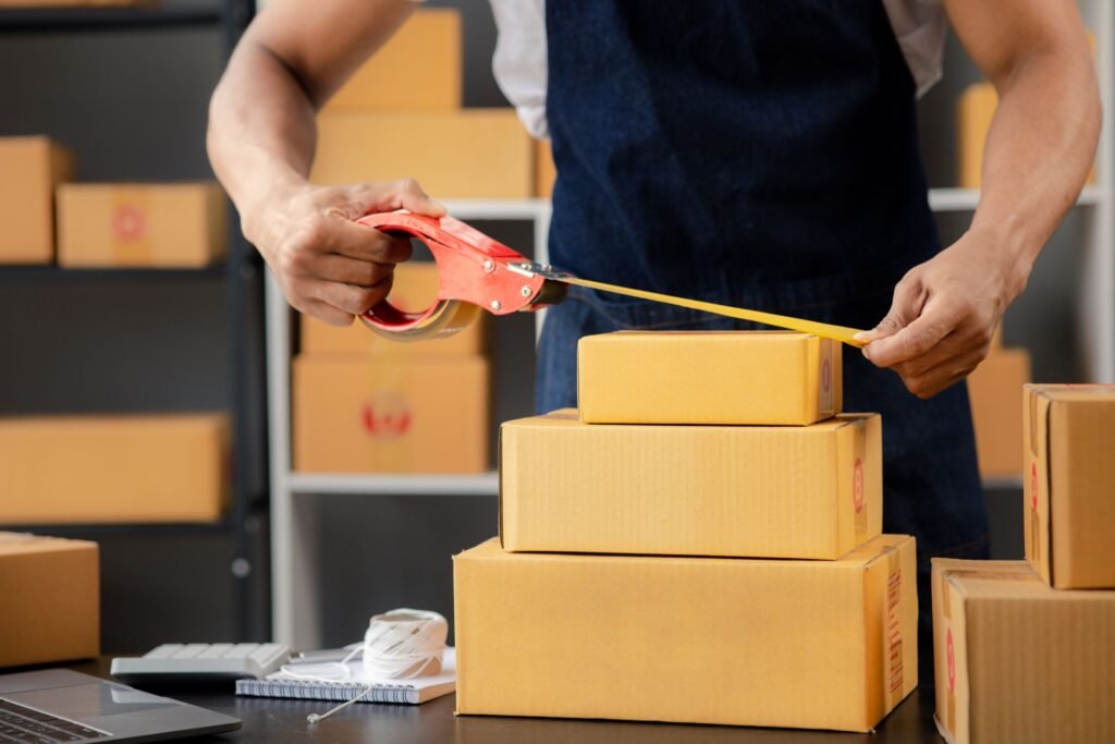 Warehouse operator measuring the length width and height of a shipping carton to calculate dimensional weight before comparing against actual scale weight