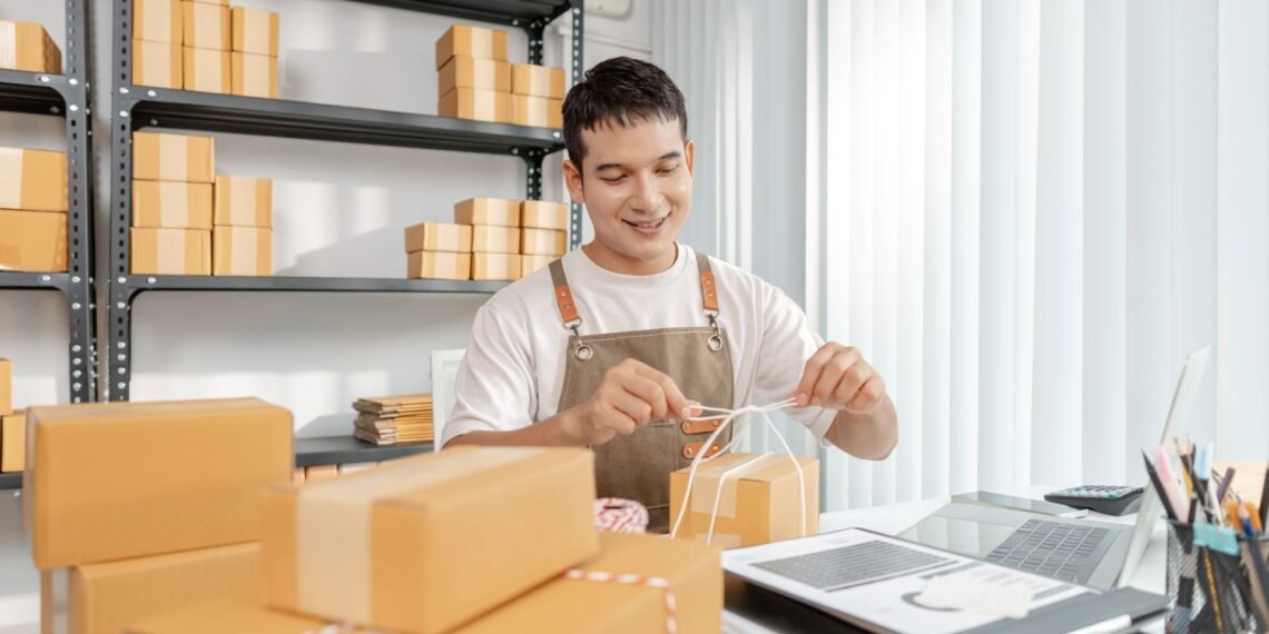 Business owner selecting a digital shipping scale at a warehouse packing station with packages ready for dispatch
