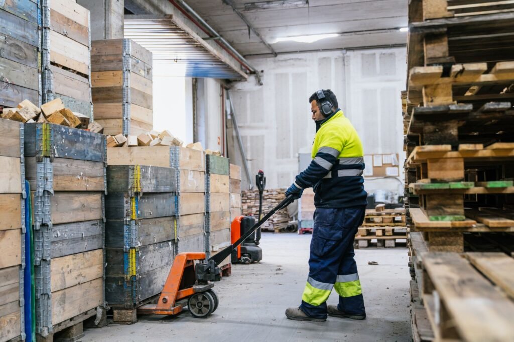 Warehouse worker verifying incoming pallet weight at a receiving dock using a portable pallet jack scale