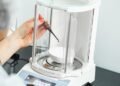 Analytical balance with a glass draft shield in a laboratory