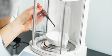 Analytical balance with a glass draft shield in a laboratory