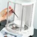 Analytical balance with a glass draft shield in a laboratory
